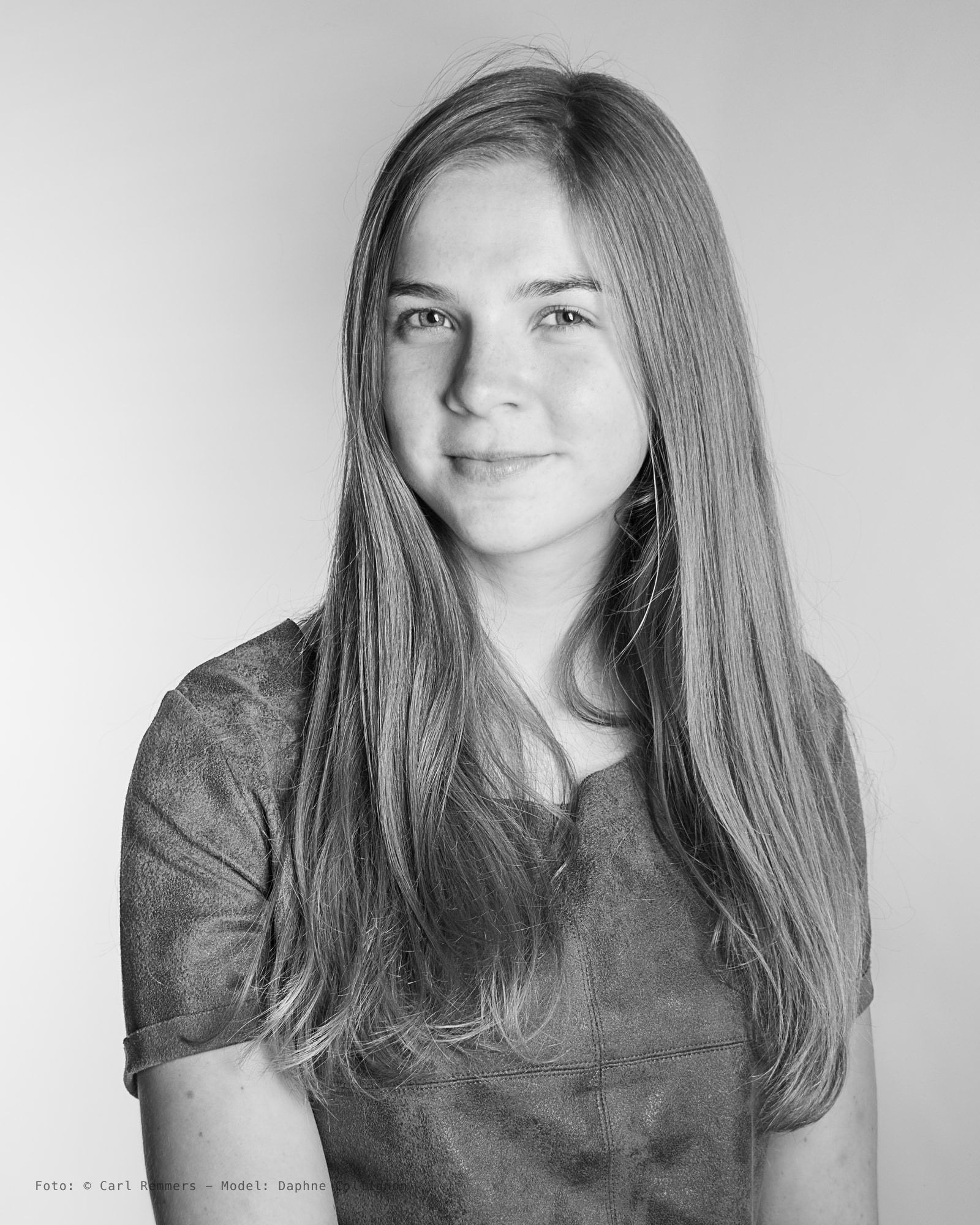 Portret van een jonge vrouw met lang haar in een suède jurk, zwart-wit