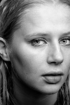 Close-up van een gezicht met nat haar langs de slapen, zwart-wit