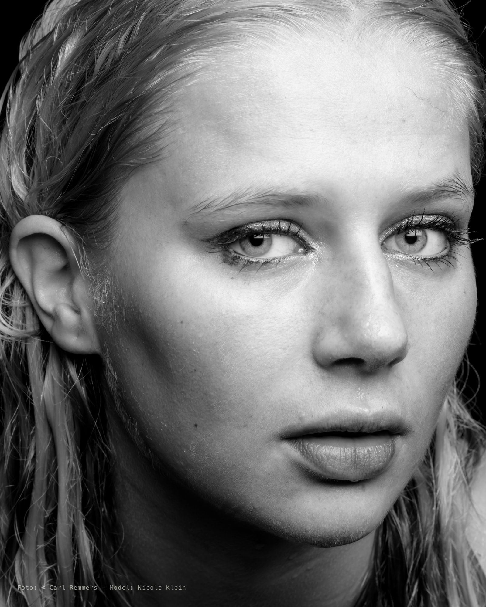 Close-up van een gezicht met nat haar langs de slapen, zwart-wit