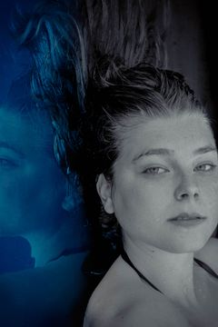 Vrouw met nat haar, gespiegeld met een blauwe helft, alsof ze onder water ligt
