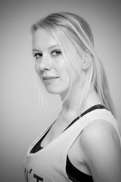 Zijportret van een vrouw met een paardenstaart in een sporttop, zwart-wit
