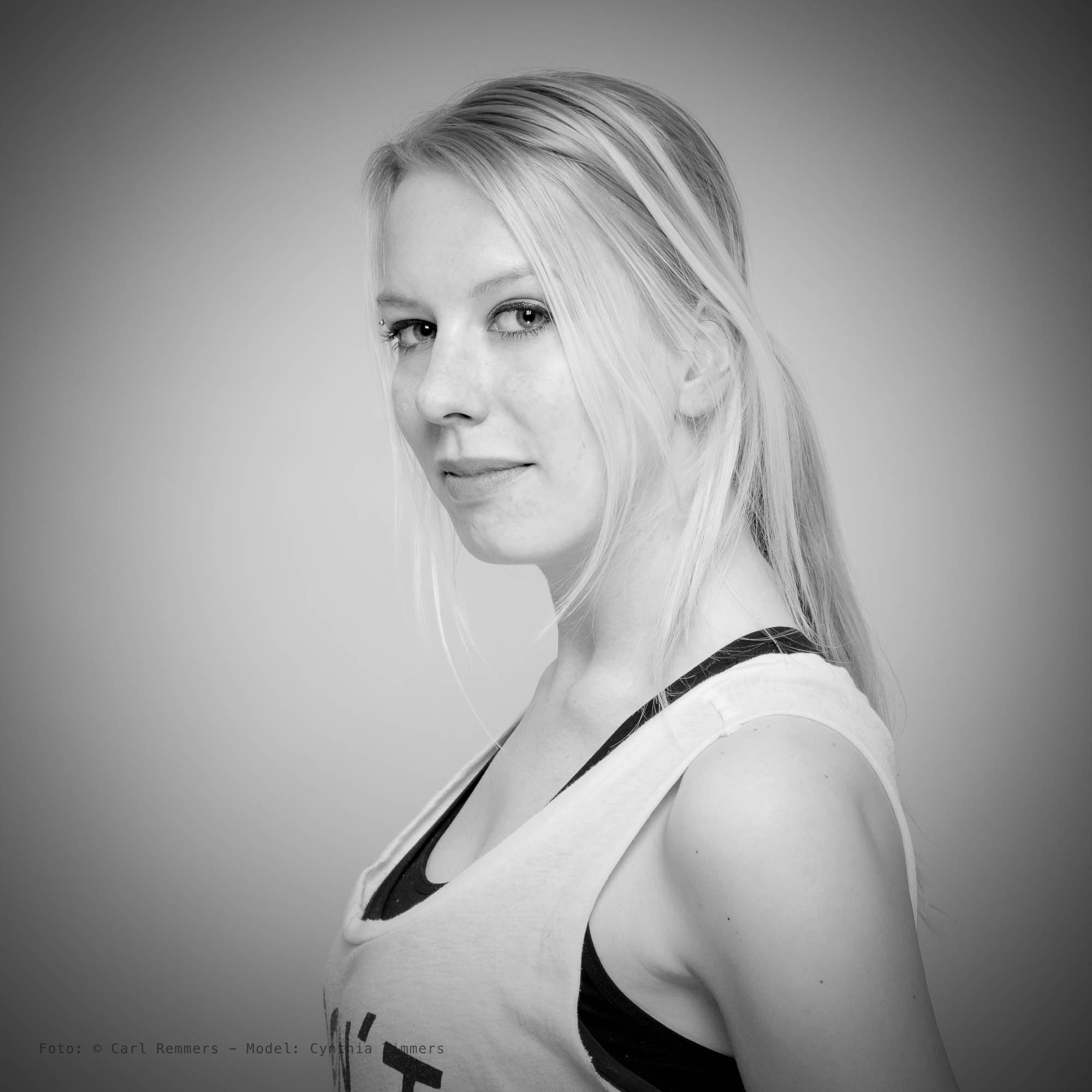 Zijportret van een vrouw met een paardenstaart in een sporttop, zwart-wit