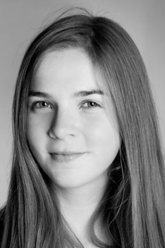 Jonge vrouw met lang steil haar tegen een lichte achtergrond, zwart-wit